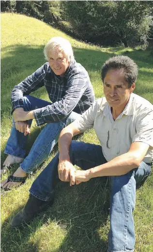  ?? Larry Pynn/ POSTM EDIA NEWS ?? Whale biologist Jim Darling, left. and native canoe carver Joe Martin sit on a grassy mound that may be filled with ancient whale bones at Echachist, near Tofino, B.C.