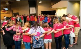  ?? Special to the NWA Democrat-Gazette ?? The host team — a group of greeters, parking lot attendants and others who focus on welcoming people to Life Church — prays together in the lobby before a service at the church’s Stillwater, Okla., location. Life Church’s second location in Arkansas will host its first service Sunday at Bentonvill­e’s Four Points by Sheraton Hotel.