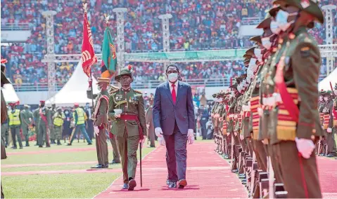  ?? | AFP ?? NEWLY elected Zambian President Hakainde Hichilema inspects the guard of honour during his inaugurati­on at the Heroes Stadium in Lusaka, yesterday.