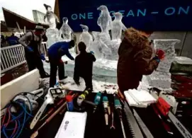  ?? ?? Members of Brilliant Ice Sculpture in Lawrence, including Don Chapelle (top), worked on a sculpture of African penguins at the New England Aquarium ahead of First Night.