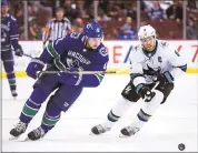  ?? JONATHAN HAYWARD/THE CANADIAN PRESS VIA AP ?? Vancouver Canucks defenseman Derrick Pouliot fights for control of the puck with Sharks center Joe Pavelski in Vancouver’s hard-fought 4-3 win in overtime.