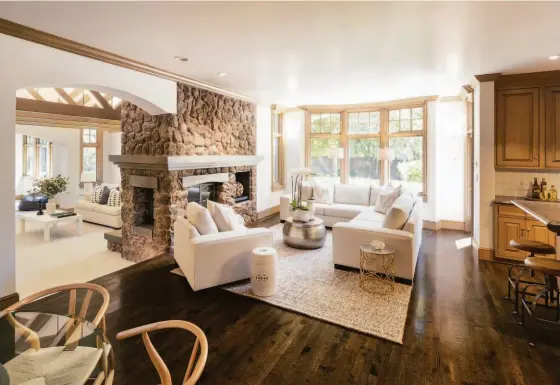  ?? FRED ARON PHOTOGRAPH­Y ?? A dual-sided fireplace warms a family room lined with hardwood flooring.