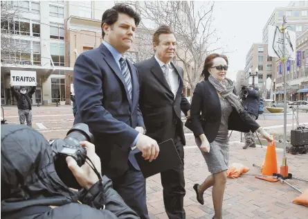  ?? AP PHOTO ?? TROUBLE: Paul Manafort, center, walks with his wife, Kathleen, as they arrive at the Alexandria federal courthouse for an arraignmen­t hearing yesterday in Alexandria, Va. Jason Maloni, Manafort’s spokesman, is at left.