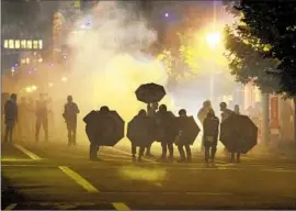  ?? Paula Bronstein Associated Press ?? TEAR GAS fills the air at 2020 protests in Portland, Ore. The Government Accountabi­lity Office could not say if the safety of such chemicals has been assessed.