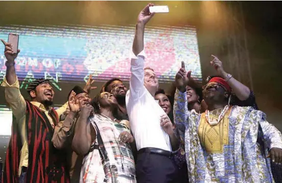  ??  ?? French President Emmanuel Macron, center, takes a selfie with some Nollywood actors at the event, which aimed to celebrate African culture