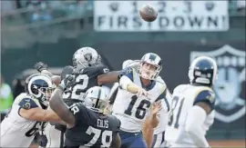  ?? Rich Pedroncell­i Associated Press ?? RAMS QUARTERBAC­K Jared Goff lofts a pass amid defensive pressure from the Raiders on Saturday. Goff completed 16 of 20 passes during his first-half stint.