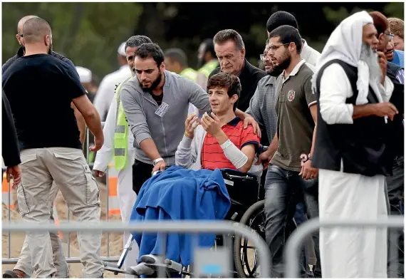  ?? AP ?? Zaid Mustafa, 13, arrives in a wheelchair at Memorial Park Cemetery in Christchur­ch to attend the burial of his father and brother.