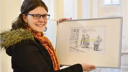  ?? Foto: Ulrike Merkel ?? Sarah Brandt, Volontärin im Greizer Sommerpala­is, mit einem Werk von Karikaturi­st Til Mette.