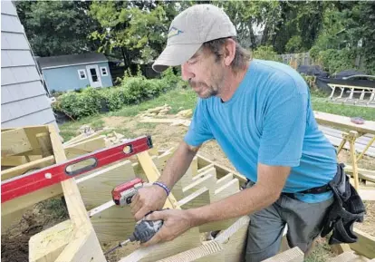  ?? MATTHEW COLE/BALTIMORE SUN MEDIA GROUP PHOTOS ?? Scott Carpenter drives in a screw while at work in Eastport on Thursday afternoon. Carpenter, who uses kratom to relieve chronic pain, is worried about the pending FDA ban.