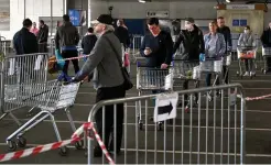  ??  ?? Wary shoppers keep their distance at a supermarke­t in Oldham