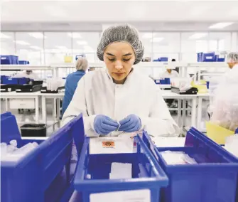  ?? Michael Short / Special to The Chronicle ?? Assembly worker Kaitlyn MarquezBai­rd assembles COVID19 testing kits at Evolve Manufactur­ing Technologi­esin Fremont. The company is making 3,000 kits a day.