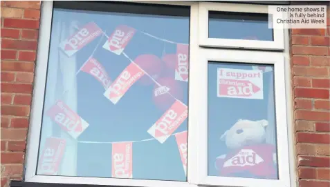  ??  ?? One home shows it is fully behind Christian Aid Week