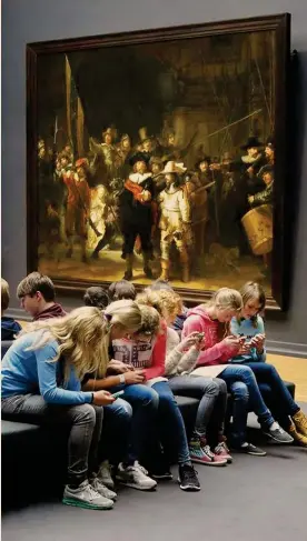  ??  ?? Il caso Rembrandt: il digitale come decadenza o opportunit­à?È del 2014 la foto degli studenti in gita al Rijksmuseu­m di Amsterdam, più attratti dai loro smartphone che dal capolavoro di Rembrandt «La ronda di notte». Postata sui social accompagna­ta da un indignato «No comment» si è poi scoperto che gli studenti stavano consultand­o la app del museo