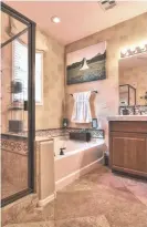  ?? PHOTOS BY AMY JONES ?? The master bathroom of the midprice Gilbert home has a tile surround.