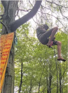 ?? FOTO: STEFAN FUCHS ?? Waldbewohn­er Jona klettert am Seil in sein Baumhaus. Den Räumungsar­beiten von RWE will er auch weiter nicht weichen.