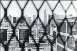  ?? OVIE CARTER/TRIBUNE FILE ?? The downtown skyline is clearly visible from one of the fenced-in hallways at CabriniGre­en on Nov. 25, 1986.