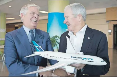  ?? CP PHOTO ?? WestJet Airlines President & CEO Gregg Saretsky, left, and board chairman Clive Beddoe share a moment of humour as they hold a model of the Boeing 787 Dreamliner after the purchase of this airplane was announced at the company’s annual general meeting...