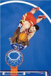  ?? MATT SLOCUM/ ASSOCIATED PRESS ?? Philadelph­ia’s Dwight Howard, bottom, goes up for a dunk against Atlanta Hawk Danilo Gallinari during the first half of Friday’s game in Philadelph­ia. The 76ers won, 126-104.