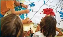  ??  ?? Paul Newman circondato dai bambini ospiti in uno dei villaggi sostenuti dalla sua Fondazione. Sotto, un gruppo di bambini realizza un puzzle con tessere di pelle, all’interno del progetto di Zanellato per Dynamo Camp