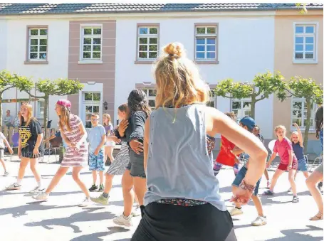  ?? FOTO: ST. ANNENHOF ?? Tanja Kontny (vorne) hat mit den Kindern vom St. Annenhof eine Woche lang den Tanz einstudier­t. Im Innenhof des Kinderheim­s in Kempen führten die Kinder nun am Dienstag ihren Tanz auf.