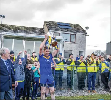  ??  ?? Eugene Mullen Easkey captain holds the cup aloft to the delight of the local supporters. Pics: Tom Callanan.