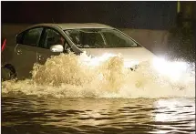  ??  ?? SPLASH: A car tackles flood water in Roath, Cardiff