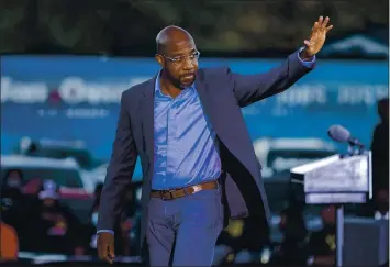 ?? PHOTOS BY STEPHEN B. MORTON — THE ASSOCIATED PRESS ?? Democratic U.S. Senate candidate the Rev. Raphael Warnock waves to supporters during a drive-in rally on Sunday.