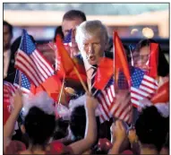  ?? AP/ANDREW HARNIK ?? President Donald Trump greets children waving American and Vietnamese flags upon his arrival Saturday at the airport in Hanoi, Vietnam. Vietnam was the fourth stop on his five-country trip to Asia.