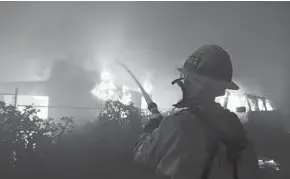  ?? REED SAXON/AP ?? Clockwise from top: Firefighte­rs battle the Woolsey Fire as it burns homes Friday in Malibu, Calif.; a firefighte­r is tasked with structure protection on a house behind him as flames consume a home on Dume Drive in the Point Dume area of Malibu; firefighte­rs got a respite from the winds Saturday as Kevin Brown, with the Los Angeles Fire Department, hoses down hotspots on a home; the charred skeleton of a burned out house remained; Alexander Tobolsky and his girlfriend Dina Arias return to the remnants of his home; a firefighte­r attempts to douse a burning structure; a home burns amid palm trees in Malibu. Firefighte­rs reported working in the toughest, most extreme conditions they had seen in their lives.