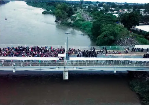  ?? GABRIELA RÍOS/EFE ?? Cientos de migrantes hondureños esperando el momento justo para cruzar la frontera entre Guatemala y México en 2018.