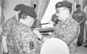  ?? — Gambar Bernama ?? KELAI BASA: Hishammudd­in ngelekatka tanda pangkat Brigadier Jeneral Askar Wataniah ngagai Kepala Menteri Sarawak, Datuk Patinggi Abang Johari Tun Openg ba Kem Muara Tuang, Kota Samarahan ditu kemari.