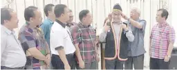  ??  ?? Manyin (second right) puts the Bidayuh traditiona­l headgear on Westmorela­nd. Also in the photo are Dr Jerip (right) and (from left, front) Dr Sinang, Henry, Ik Pahon and Ranum.