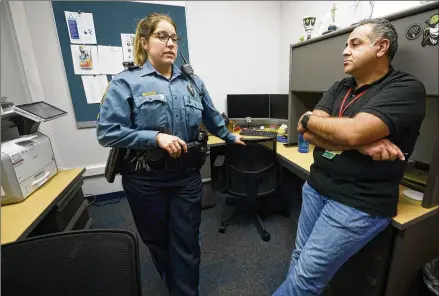  ?? DANIEL VARNADO FOR THE AJC ?? Gwinnett County police Cpl. Tracey Reed (left) chats recently with Pej Mahdavi, director of intensive outpatient services at View Point Health, at the Gwinnett Police Department. The two form the Behavioral Health Unit, offering resources for those who interact with police.