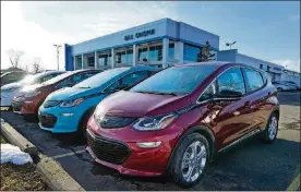  ?? AP PHOTO/CARLOS OSORIO ?? A 2021 Chevrolet Bolt EV, is displayed with 2020 models at Bill Crispin Chevrolet on Feb. 25 in Saline, Mich. Opinion polls show that most Americans would consider an EV if it cost less, there were more charging stations along freeways, and if automakers offered a bigger variety of models.