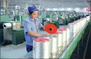  ?? HU QINGMING / FOR CHINA DAILY ?? A worker packages glass fiber products at China Jushi Co Ltd’s factory in Jiujiang, Jiangxi province.