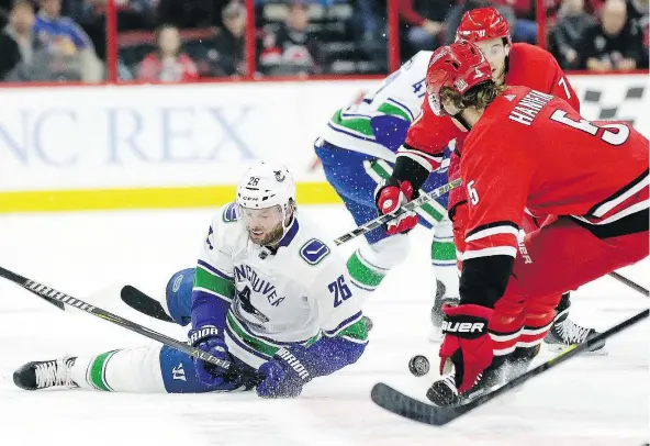  ?? — THE ASSOCIATED PRESS FILES ?? Canucks forward Thomas Vanek falls to the ice while chasing the puck with Hurricanes defenceman Noah Hanifin during the first period of Friday’s game in Raleigh, N.C. The Canucks were never in this one, falling 4-1.