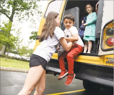  ?? Tyler Sizemore / Hearst Connecticu­t Media file photo ?? Counselor Megan Maher helps students down from the school bus emergency exit during a drill at the American Red Cross “Safety Town” program at Eastern Greenwich Civic Center in Old Greenwich on Jun. 13, 2019.