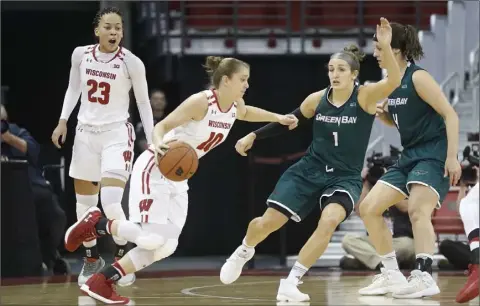  ??  ?? Wisconsin Badger Guard Kendra Van Leeuwen (10) tries to get around Green Bay Phoenix Guard Jen Wellnitz (1).