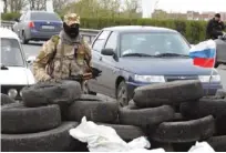  ??  ?? An armed pro-Russian activist guards a check-point on the KharkivDon­etsk road near the entrance to the eastern Ukrainian city of Slavyansk yesterday.—AFP