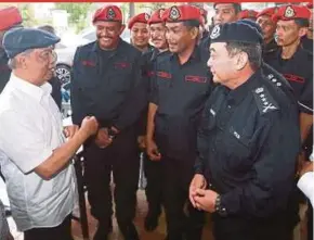  ?? PIC BY SAIRIEN NAFIS ?? Home Minister Tan Sri Muhyiddin Yassin (left) meeting police personnel on duty at the Sri Maha Mariamman Temple in Subang Jaya yesterday.