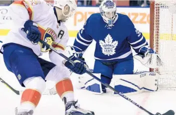  ?? FRANK GUNN/AP ?? Panthers center Aleksander Barkov looks for an opening as Maple Leafs goalie Curtis McElhinney challenges his during the first period in Toronto.