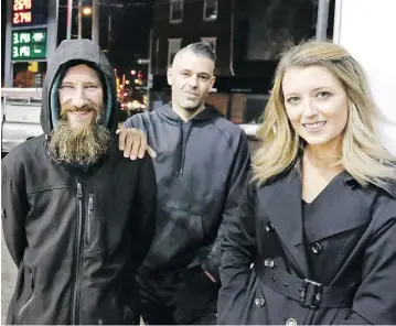  ?? ELIZABETH ROBERTSON / THE PHILADELPH­IA INQUIRER VIA THE ASSOCIATED PRESS FILES ?? Johnny Bobbitt, left, Mark D’Amico and his girlfriend Kate McClure in 2017 at a Citgo station in Philadelph­ia, where the homeless Bobbitt gave his last $20 to a stranded McClure to buy gas for her car.