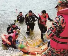  ??  ?? ANGGOTA bomba mengangkat mayat mangsa.