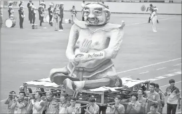  ??  ?? University students carry a parade float of a mythical creature representi­ng Prawit, mocking him over his undeclared collection of luxury watches, during the annual football match between Thammasat University and Chulalongk­orn University in Bangkok. —...