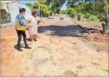  ??  ?? Las vecinas muestran las obras precarias no terminadas sobre la calle Panchito López, del barrio Tayazuapé.