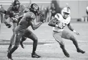  ?? ROB KINNAN USA TODAY Sports ?? UM running back Mark Fletcher Jr., right, looks to avoid the tackle by North Carolina State cornerback Shyheim Battle on Saturday. Fletcher finished with 23 carries for 115 yards.