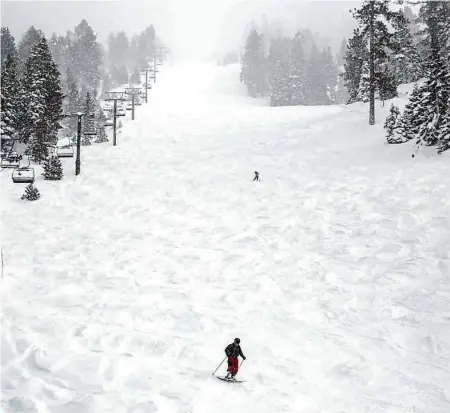  ?? Salgu Wissmath/The Chronicle ?? A skier and a snowboarde­r make the last run after lifts closed in the afternoon at Heavenly Mountain Resort in South Lake Tahoe on Tuesday. A winter storm shut the resort, along with Homewood Mountain Resort and Sugar Bowl Resort, on Sunday.