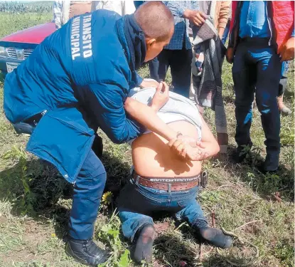  ??  ?? Un elemento de seguridad se lleva a uno de los que supuestame­nte habían fotografia­do a menores.