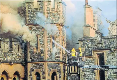  ?? ?? Firefighte­rs dampen the fire after the devastatin­g overnight blaze at Windsor Castle in 1992