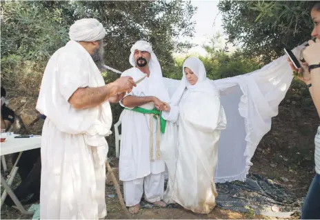  ?? Photos Sebastian Castelier for The National ?? Tarmida Nethan Kremdi Al Sabbahi conducts a Mandaean wedding in Jordan in April. The Mandaean diaspora is now spread across the world due to persecutio­n in Iraq that prompted many to flee their religious homelands